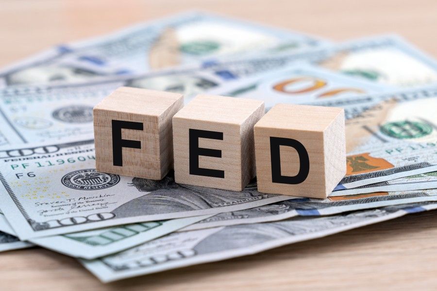 Wooden FED blocks on U.S. dollar bills.